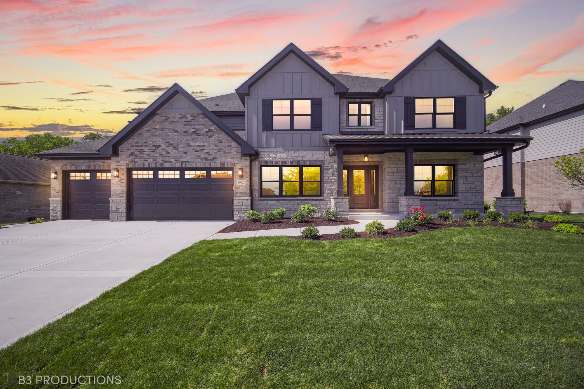 Silverline Builders custom home with a stone and board-and-batten facade, photographed at sunset